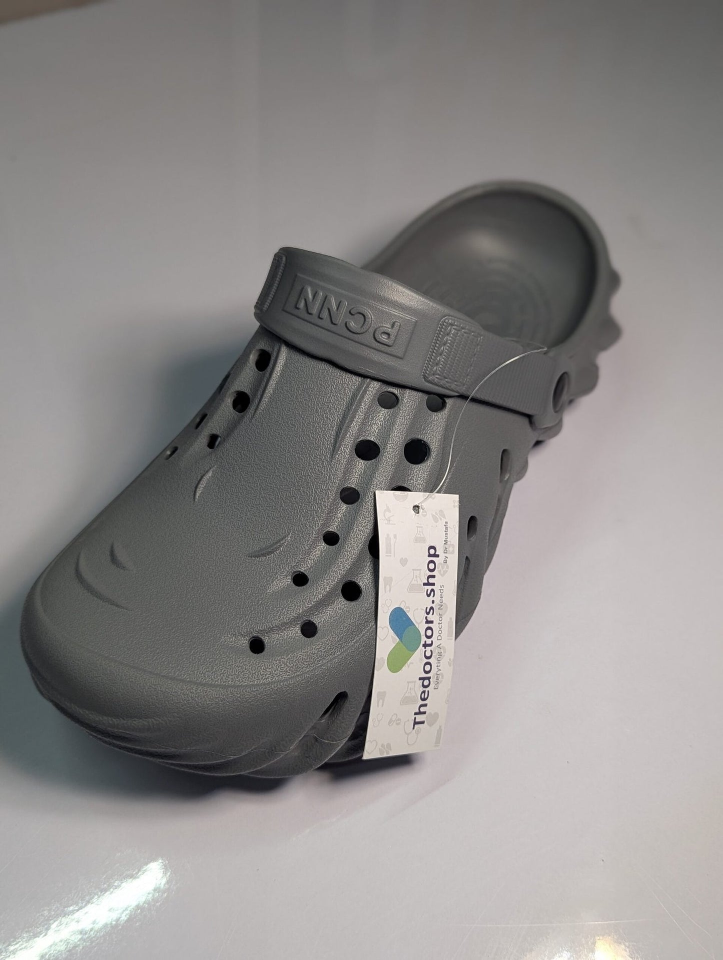 Pair of beige PGM medical clogs with ventilation holes and adjustable heel strap, displayed with TheDoctors.shop tag