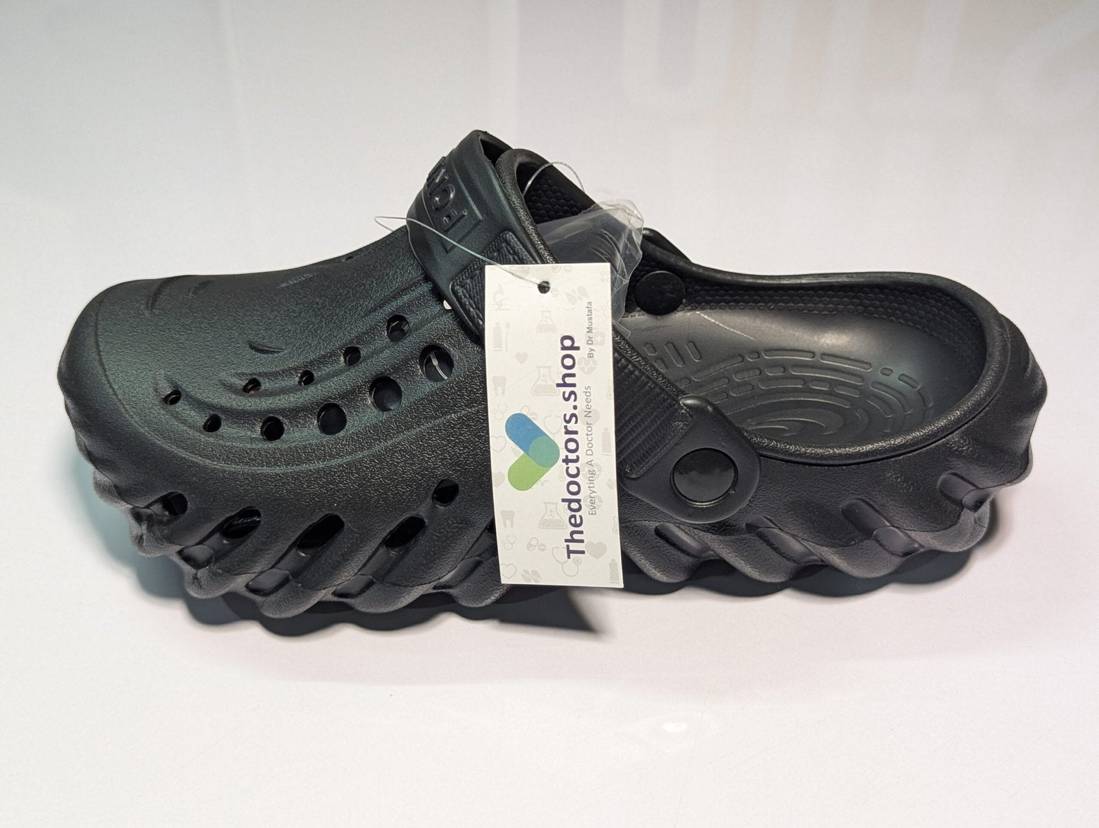 Pair of beige PGM medical clogs with ventilation holes and adjustable heel strap, displayed with TheDoctors.shop tag