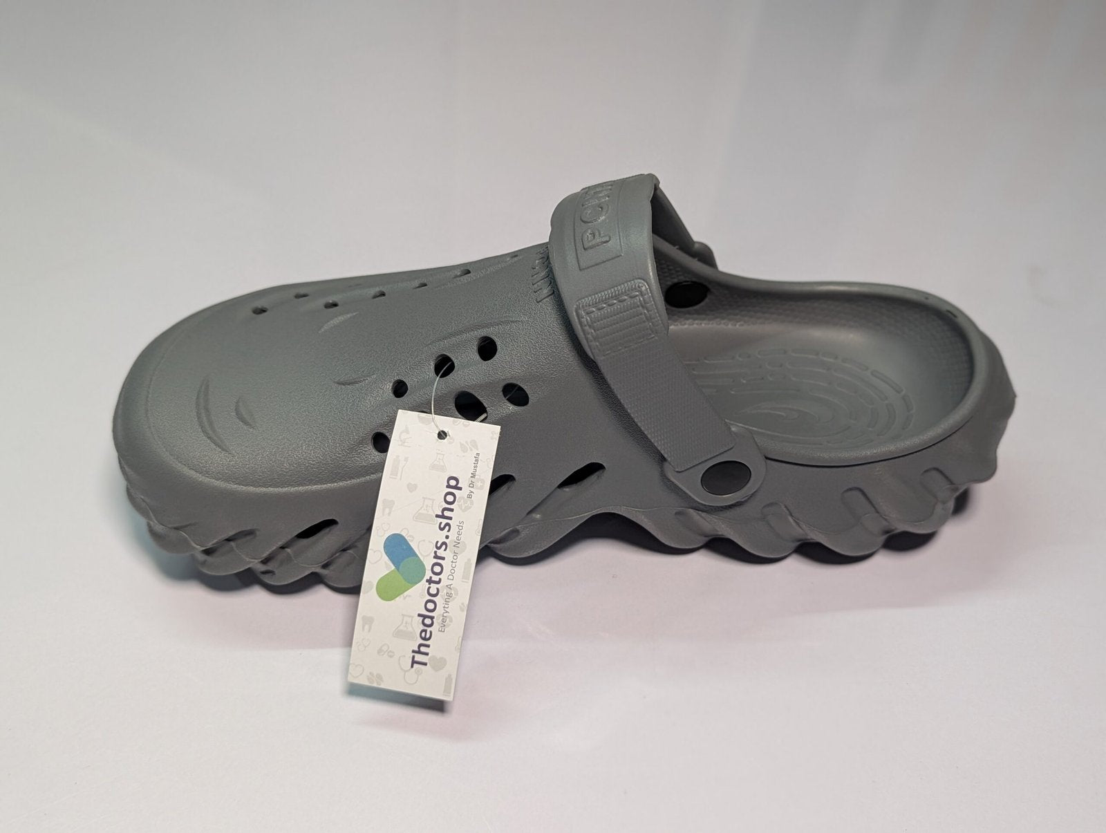 Pair of beige PGM medical clogs with ventilation holes and adjustable heel strap, displayed with TheDoctors.shop tag