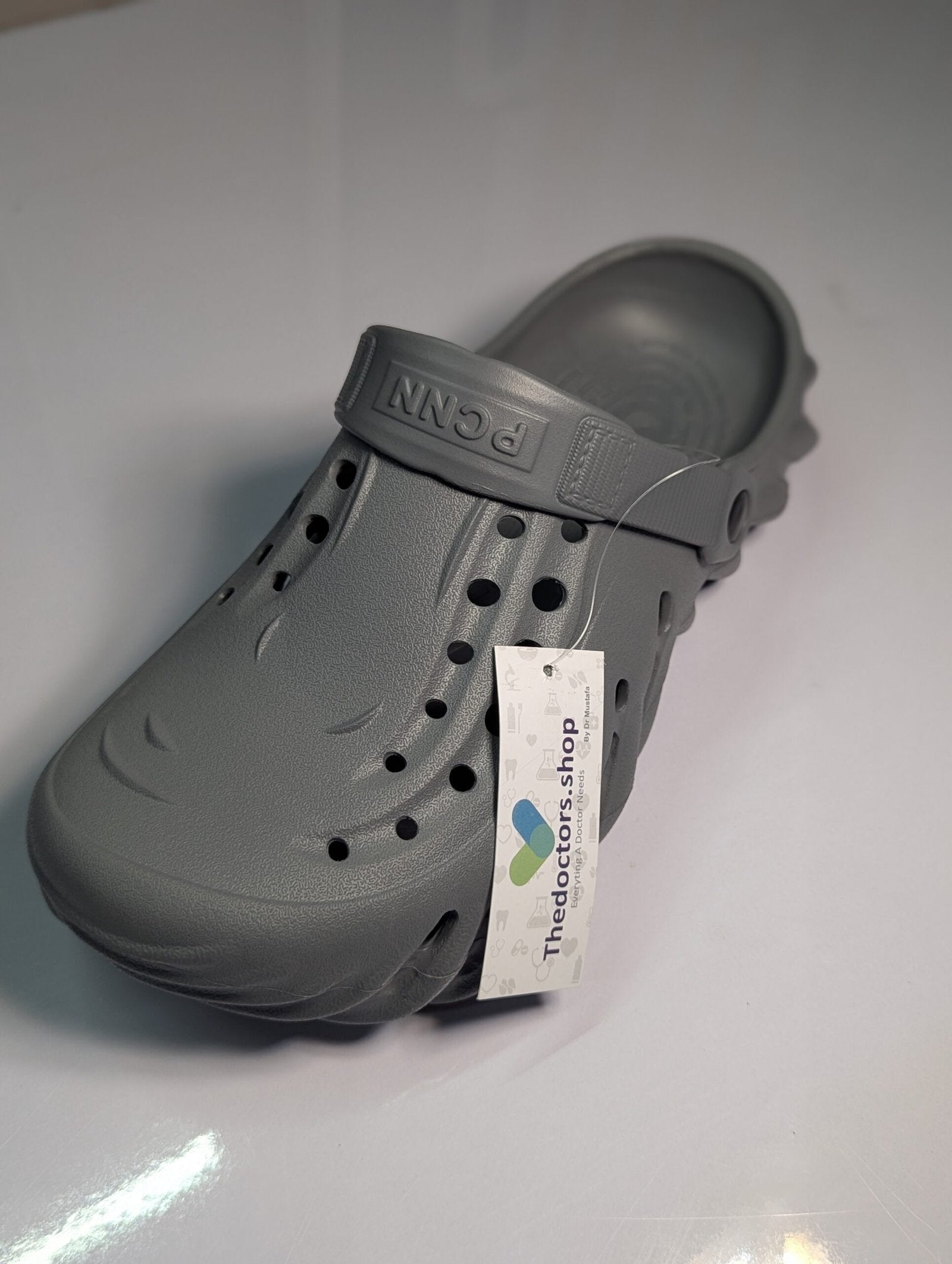 Pair of beige PGM medical clogs with ventilation holes and adjustable heel strap, displayed with TheDoctors.shop tag