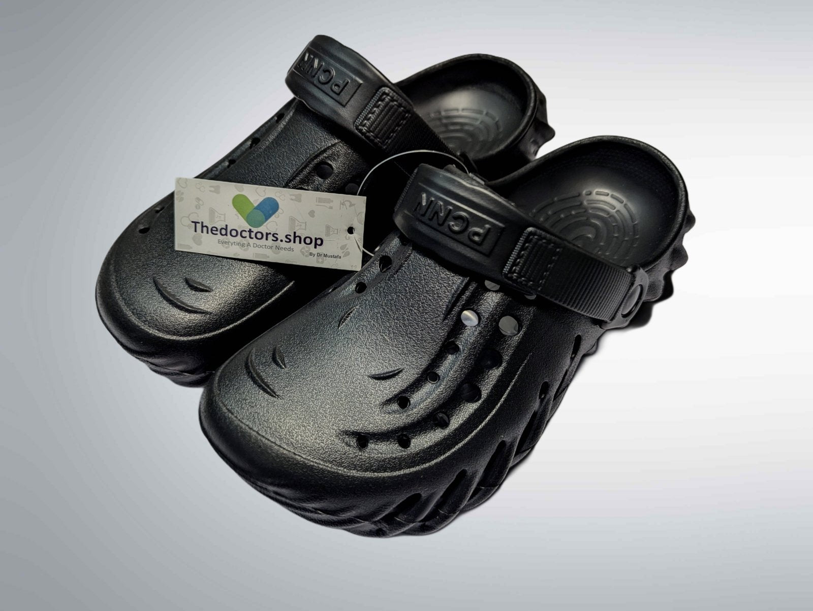 Pair of beige PGM medical clogs with ventilation holes and adjustable heel strap, displayed with TheDoctors.shop tag
